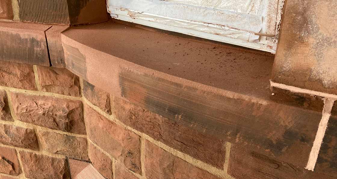 Example of a Lithomex repair to one of the curved bay cill stones, new indented lintel stone below