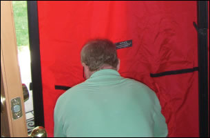 A blower door unit being fitted to conduct an air pressurisation test on a dwelling A blower door unit being fitted to conduct an air pressurisation test on a dwelling
